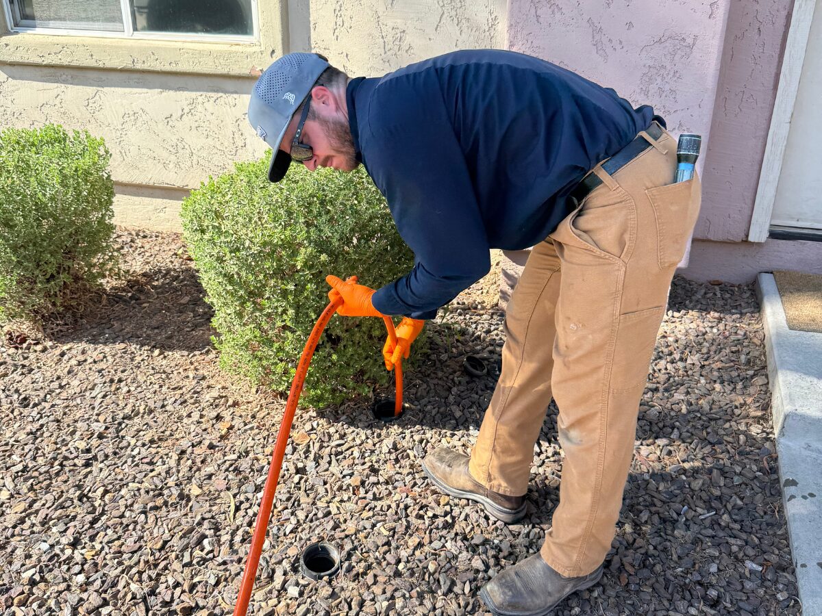 Water Pros technician clearing an outdoor drain line in Gilbert