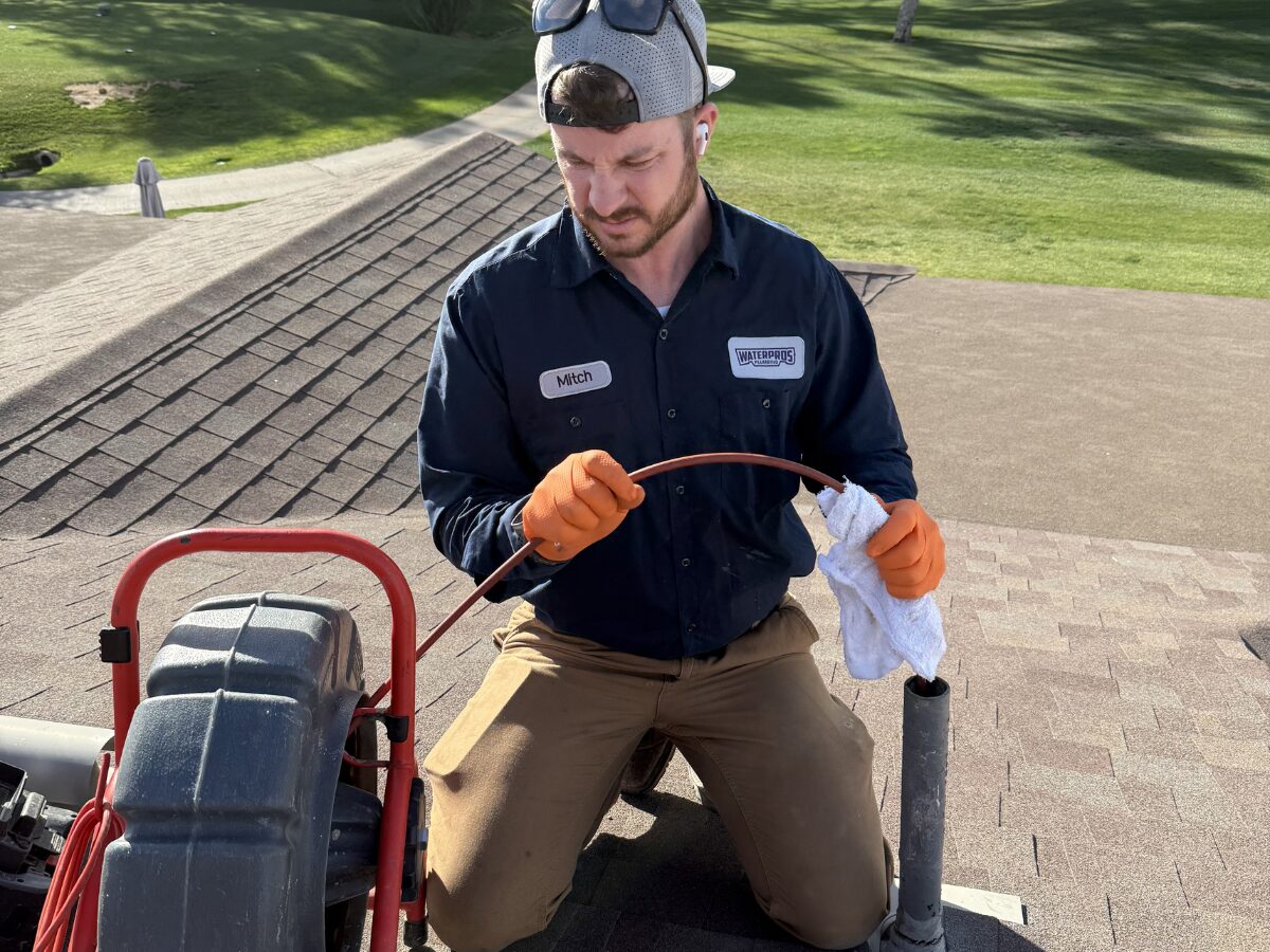 Water Pros technician using advanced drain cleaning equipment on a Gilbert rooftop