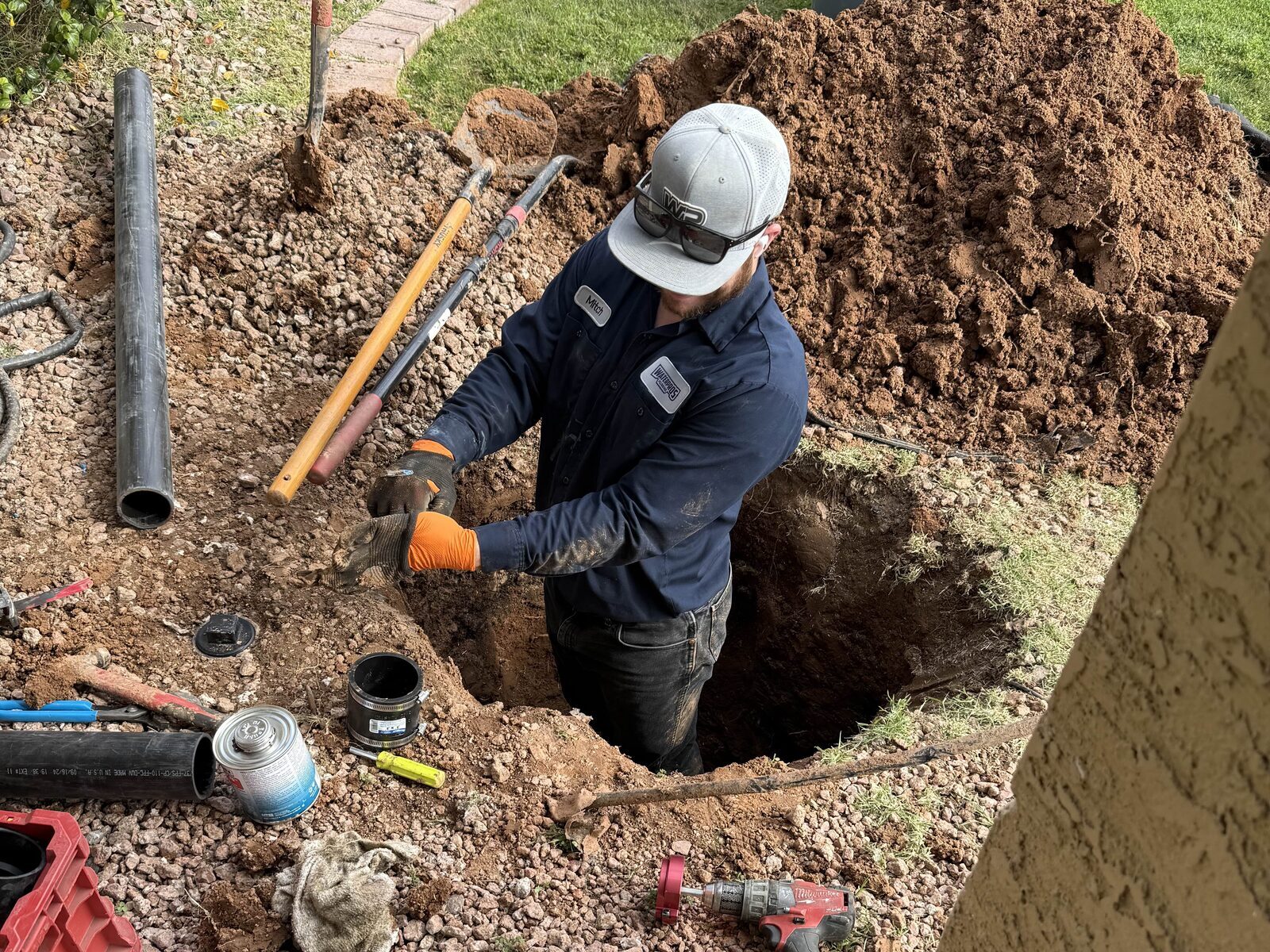 Water Pros Plumbing technician excavating to repair an underground pipe at a Gilbert home