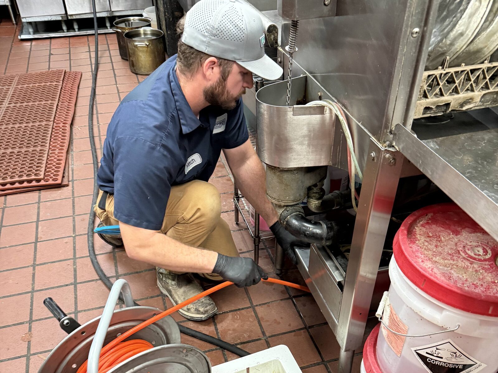 Water Pros Plumbing technician clearing a commercial kitchen drain line in Gilbert